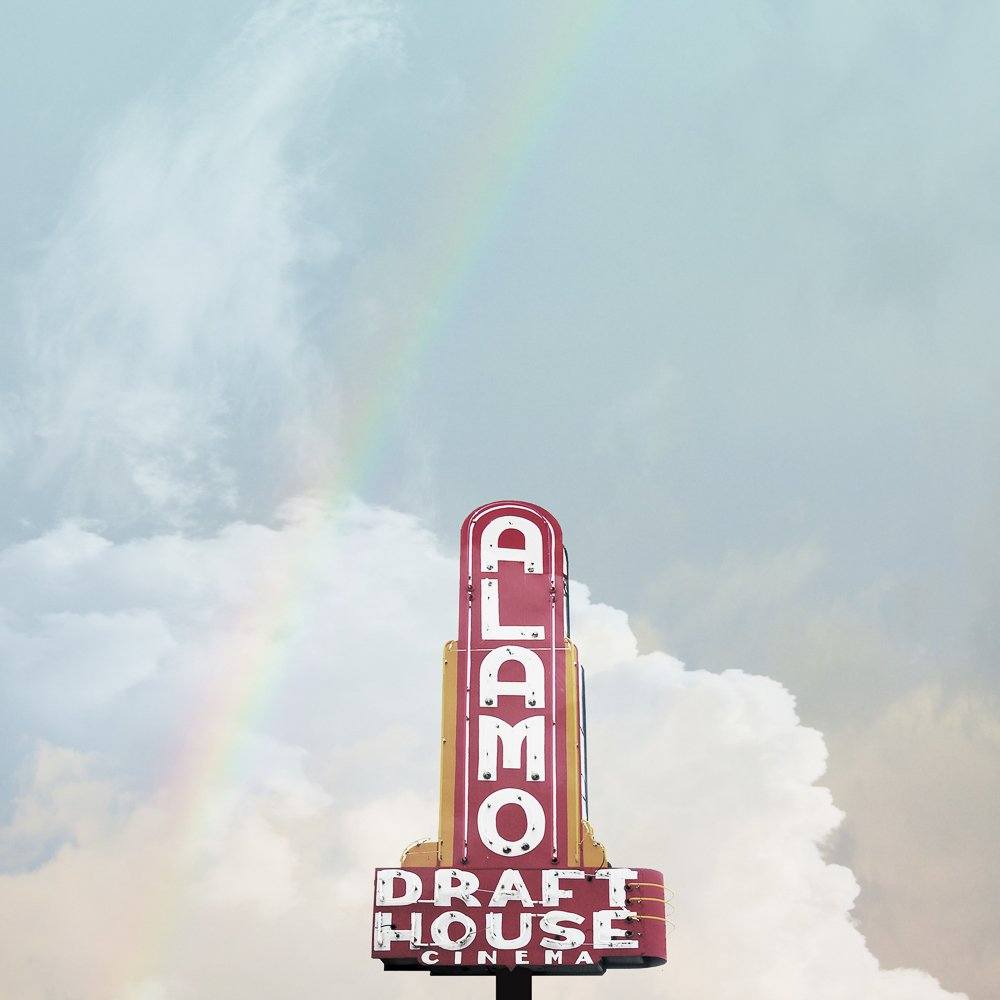 Alamo Drafthouse Austin Art vintage cinema sign with rainbow and cloudy Texas sky backdrop