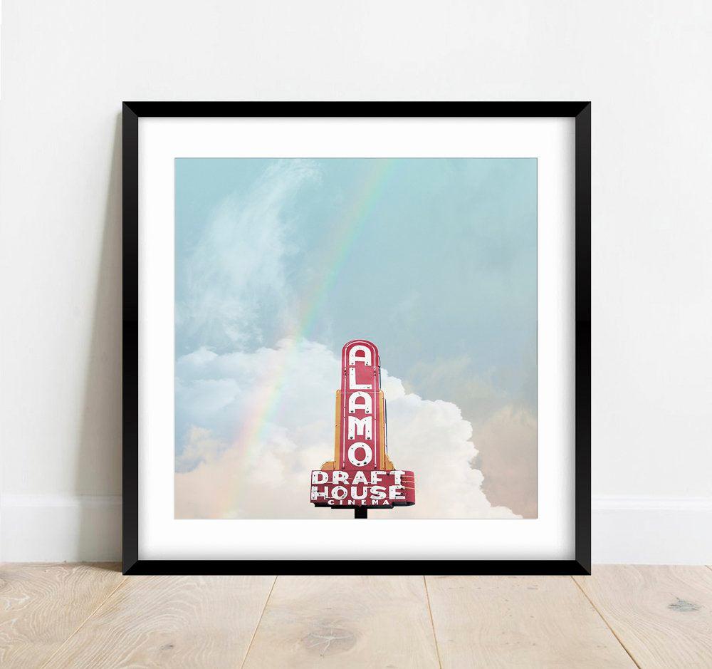 Framed Alamo Drafthouse Austin Art print featuring vintage theater sign with rainbow and cloudy sky background.