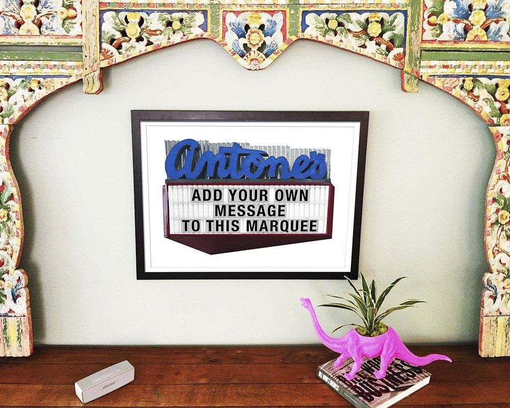 Antones Sign Austin Print by Carl Crum framed on wall with pink dinosaur planter on wooden table
