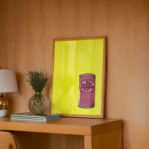 Pop of Yellow Dr Pepper art print by Betsy Crum — framed in a wood-accent room