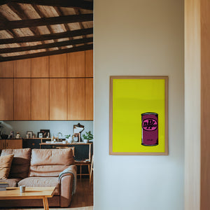 Pop of Yellow Dr Pepper art print by Betsy Crum — framed in a wood-accent room