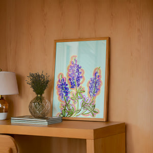 Blue Hill Country bluebonnet art print by Betsy Crum — framed in a wood-accent room