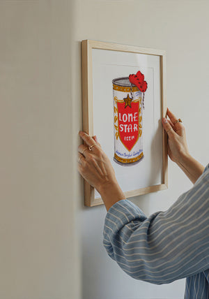 Lone Star beer print by Caya Crum being hung on a wall