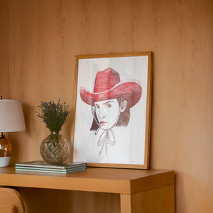 Pen & Ink Self Portrait cowgirl art print by Caya Crum — framed in a wood-accent room