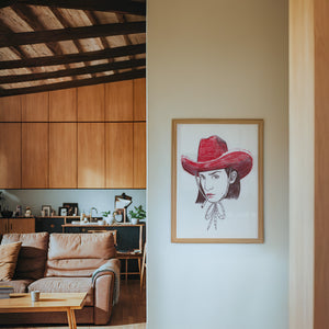 Pen & Ink Self Portrait cowgirl art print by Caya Crum — framed in a wood-accent room