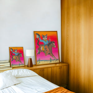 Cat Cowboy Bronco cat art print by Caya Crum — framed in a wood-accent room