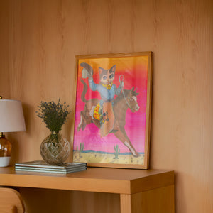 Cat Cowboy Bronco cat art print by Caya Crum — framed in a wood-accent room