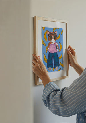 Banana Kitty cat art print by Caya Crum — being hung on a wall