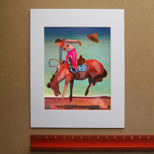 Cowgirl Bronc Rider, Hat Flying by Caya Crum, shown in a room