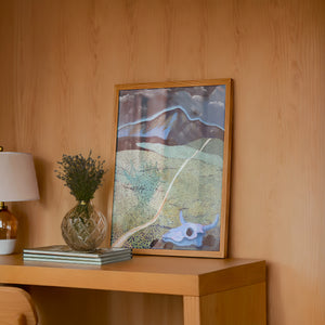 New Mexico Mountain and Field landscape print by Caya Crum — framed in a wood-accent room