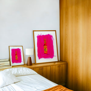 Cholula Hot Sauce kitchen art print by Caya Crum — framed in a wood-accent room