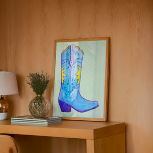 Fort Worth Boot Blue cowboy boot art print by Caya Crum — framed in a wood-accent room