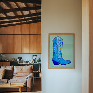 Fort Worth Boot Blue cowboy boot art print by Caya Crum — framed in a wood-accent room