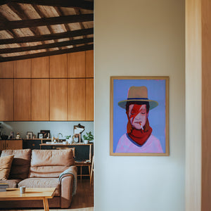 Cowboy Bowie music wall art print by Caya Crum — framed in a wood-accent room