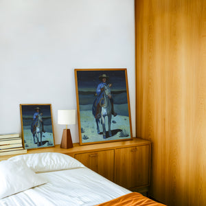 Cowboy with a Baguette at Night cowboy art print by Caya Crum — framed in a wood-accent room