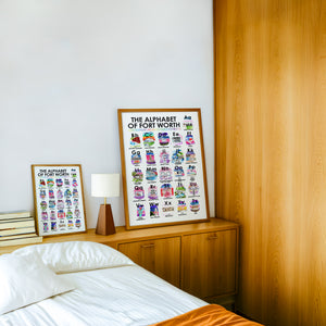 Alphabet of Fort Worth art print by Caya Crum — framed in a wood-accent room
