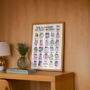 Alphabet of Fort Worth art print by Caya Crum — framed in a wood-accent room