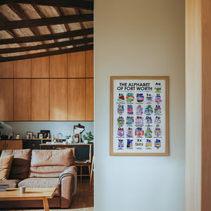 Alphabet of Fort Worth art print by Caya Crum — framed in a wood-accent room