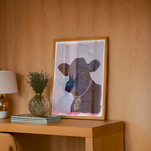 Money Cow cow wall art by Caya Crum — framed in a wood-accent room