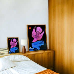 Pink & Blue Birds at Night bird art print by Caya Crum — framed in a wood-accent room