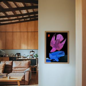Pink & Blue Birds at Night bird art print by Caya Crum — framed in a wood-accent room