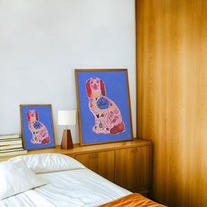 Pink Staffordshire Luck Dog maximalist dog art print by Caya Crum — framed in a wood-accent room