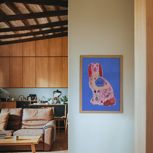 Pink Staffordshire Luck Dog maximalist dog art print by Caya Crum — framed in a wood-accent room