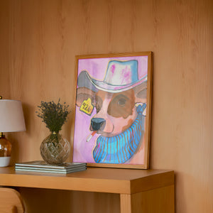 Hazel cow art print by Caya Crum — framed in a wood-accent room