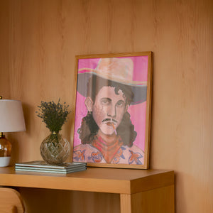Timothy tattooed cowboy art print by Caya Crum framed in a wood-accent room