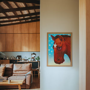 Star Horse Dreamer horse art print by Caya Crum — framed in a wood-accent room