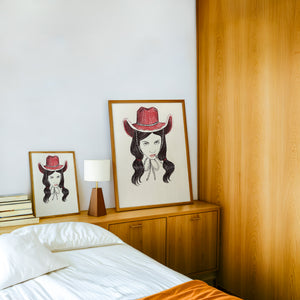 Tavi cowgirl art print by Caya Crum — framed in a wood-accent room