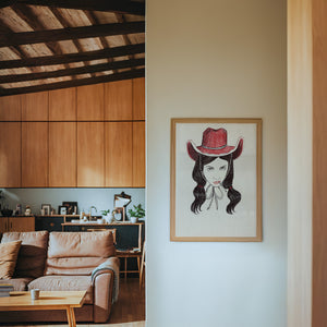 Tavi cowgirl art print by Caya Crum — framed in a wood-accent room