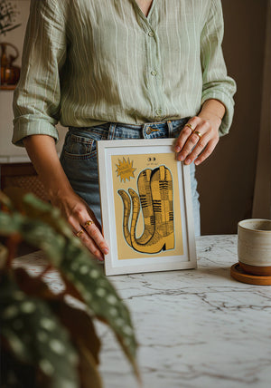Roach Stompers cowboy boot art print by Caya Crum — neutral frame room mockup
