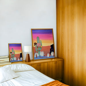 Howdy Hotel Neon cactus art print by Caya Crum — framed in a wood-accent room