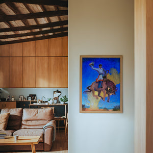 Bronco Buster Night rodeo art print by Caya Crum — framed in a wood-accent room