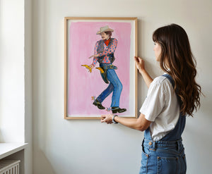 Banana Guns cowboy art print by Caya Crum — framed vertical room scene