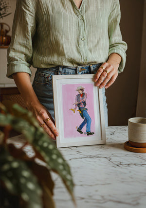 Banana Guns cowboy art print by Caya Crum — neutral frame room mockup