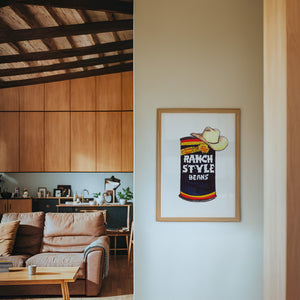 Ranch Style Beans Sketchbook kitchen art print by Caya Crum — framed in a wood-accent room