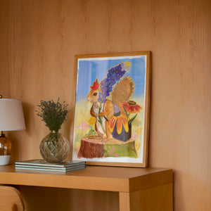 Ms. Squirrel in the Bluebonnets squirrel art print by Caya Crum — framed in a wood-accent room