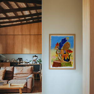 Ms. Squirrel in the Bluebonnets squirrel art print by Caya Crum — framed in a wood-accent room