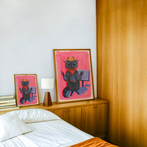 Raccoon Bandit weirdcore art print by Caya Crum — framed in a wood-accent room