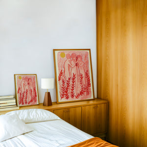 Greco Roman Dancing Maidens pink wall art print by Caya Crum — framed in a wood-accent room