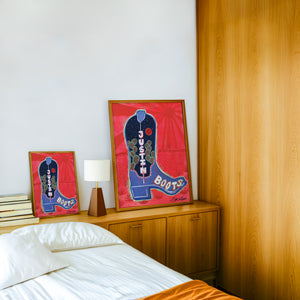 Justin Boot cowboy boot art print by Caya Crum — framed in a wood-accent room