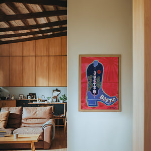 Justin Boot cowboy boot art print by Caya Crum — framed in a wood-accent room