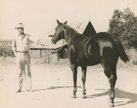 Vintage cowboy holding horse rope in black and white Texas ranch photo