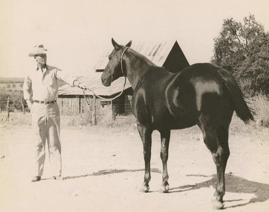 Vintage black and white photo of cowboy holding horse reins on ranch ranch vintage cowboy & se art print