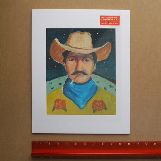 Cowboy Smoking Print featuring a cowboy in a yellow shirt with red roses, blue bandana, and cowboy hat, signed art print by Caya Crum on cotton rag paper.
