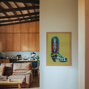 Leddy Boot Ochre cowboy boot art print by Betsy Crum — framed in a wood-accent room