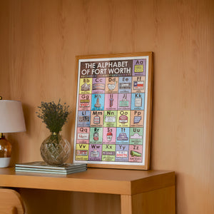 Alphabet Nursery Decor Fort Worth art print by Betsy Crum — framed in a wood-accent room