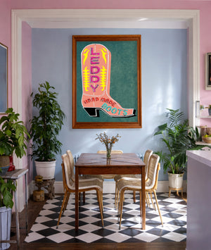 Pink Leddy cowboy boots print by Betsy Crum framed in a pink and blue room